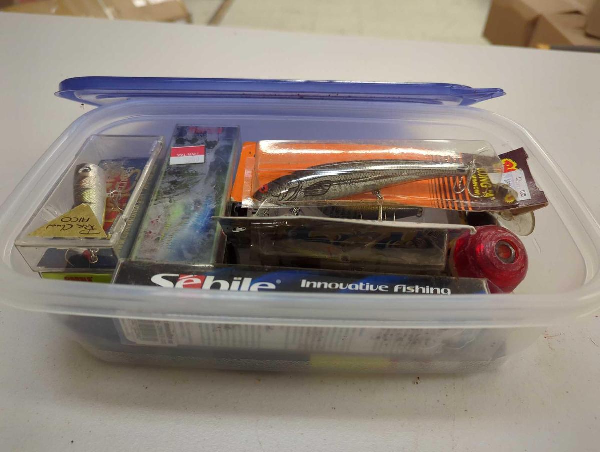 Container and contents including various fishing lures of similar style. Comes as is shown in