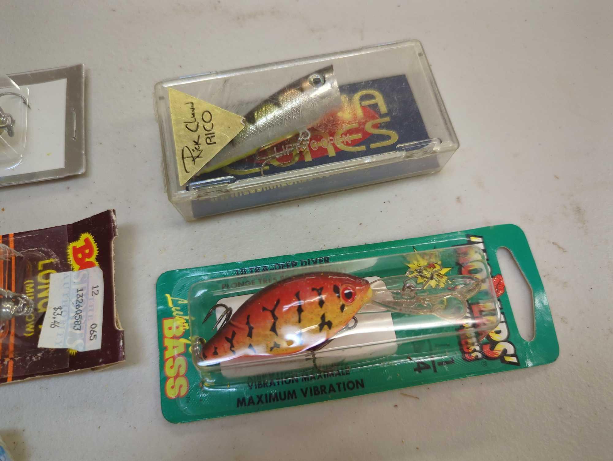 Container and contents including various fishing lures of similar style. Comes as is shown in